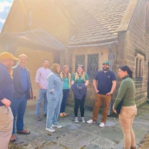 A group gathers around Ford House Director of Preservation, Rebecca Torsell.
