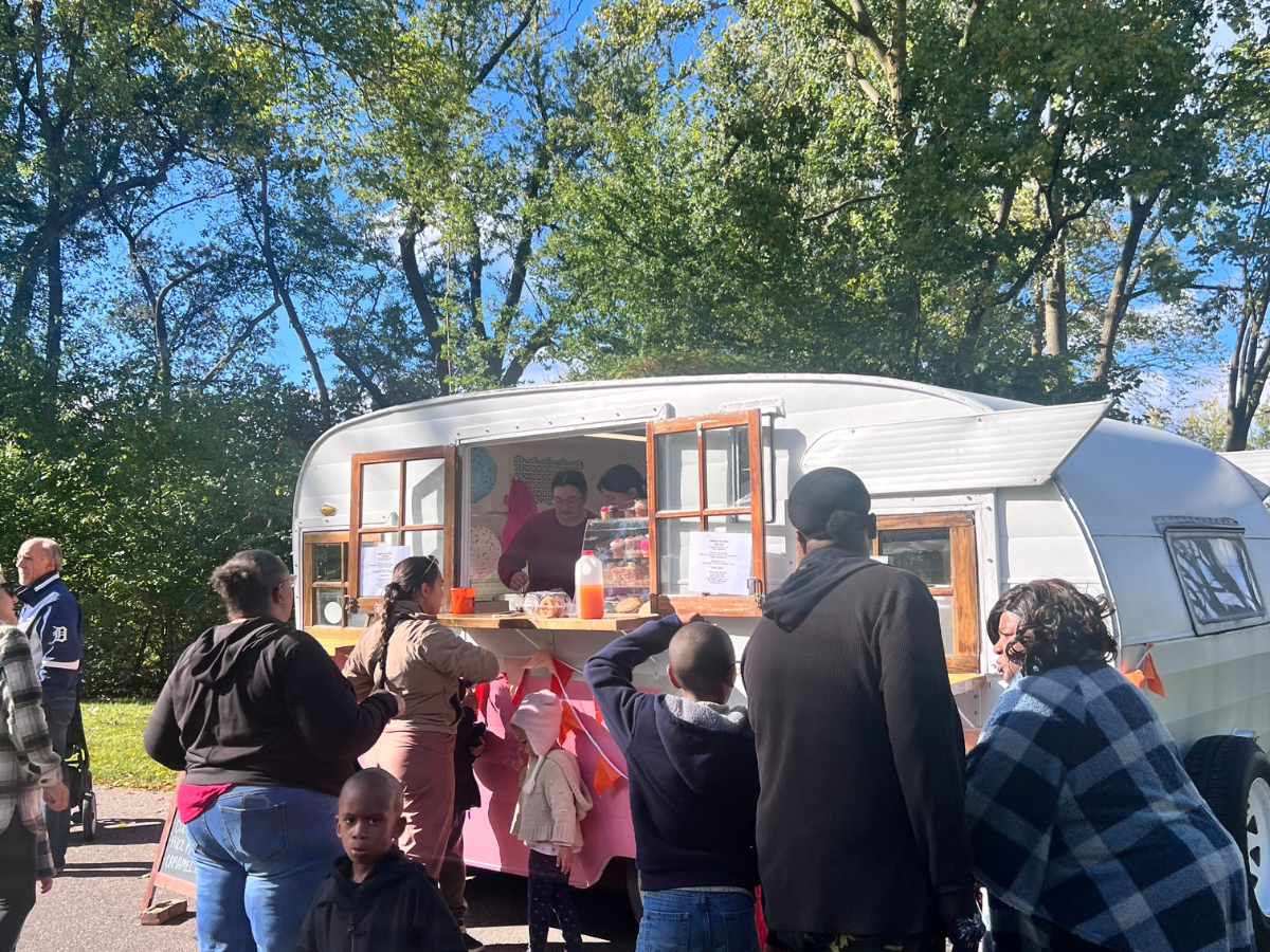 Guests gathered at a retro-style food truck during Harvest Day, ordering food and drinks on a sunny afternoon.