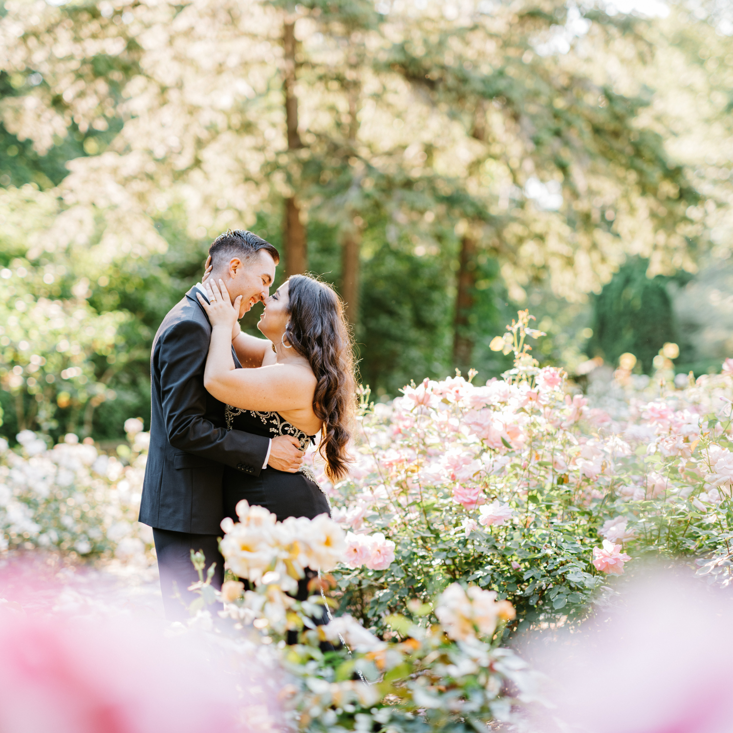 Engaged couple embracing in a blooming garden at Ford House during a golden-hour professional photo session.