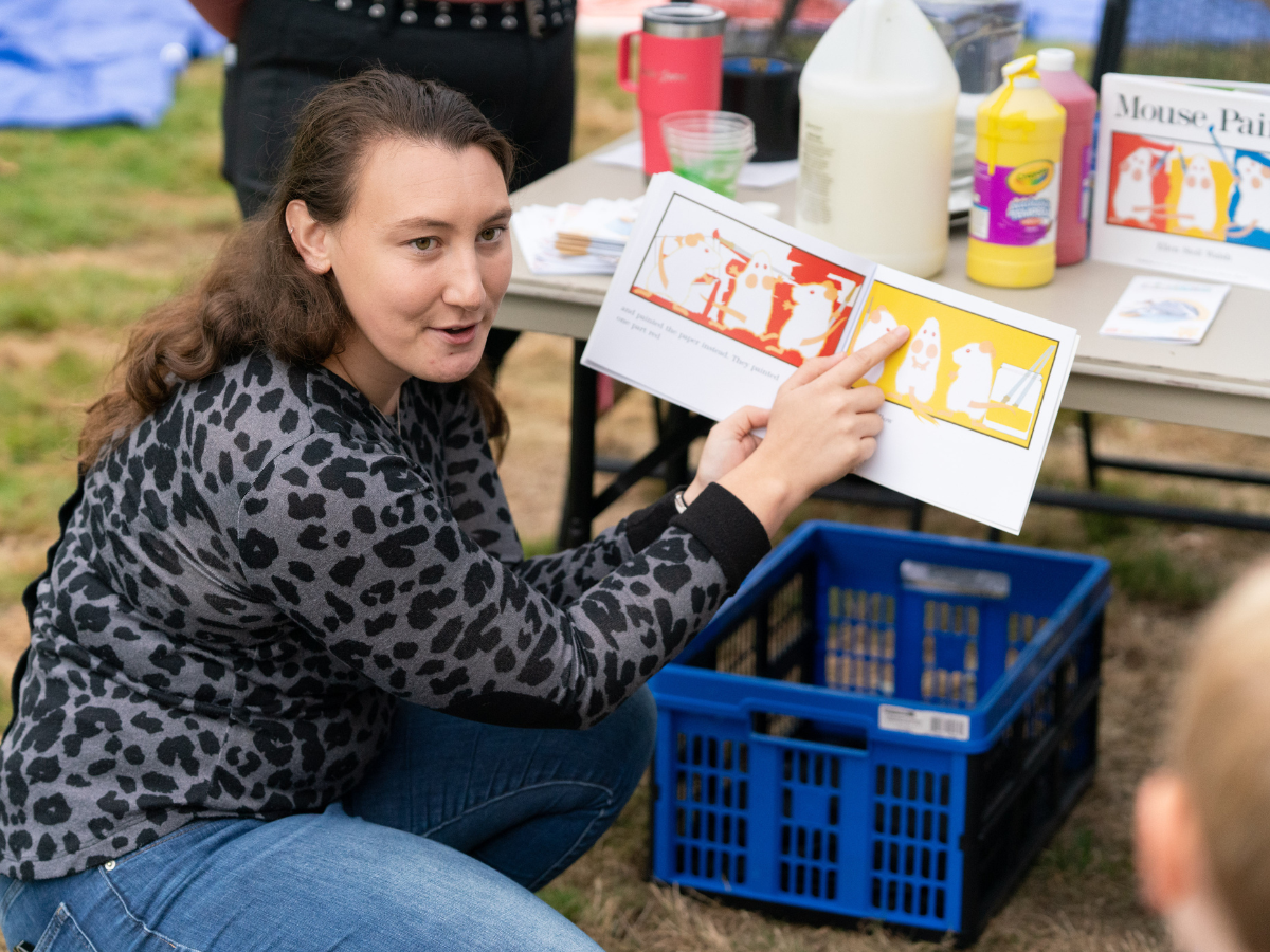 Woman reading Mouse Paint aloud to children during Story Festival at Ford House.